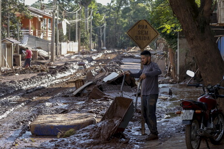 Homem retira lama de casa inundada em Cruzeiro do Sul, no Rio Grande do Sul